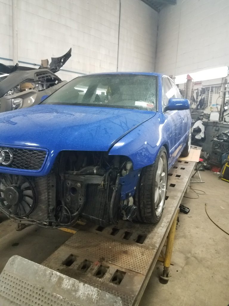 Blue Audi S4 on the frame straightening machine at Universe Auto Body in the Bronx