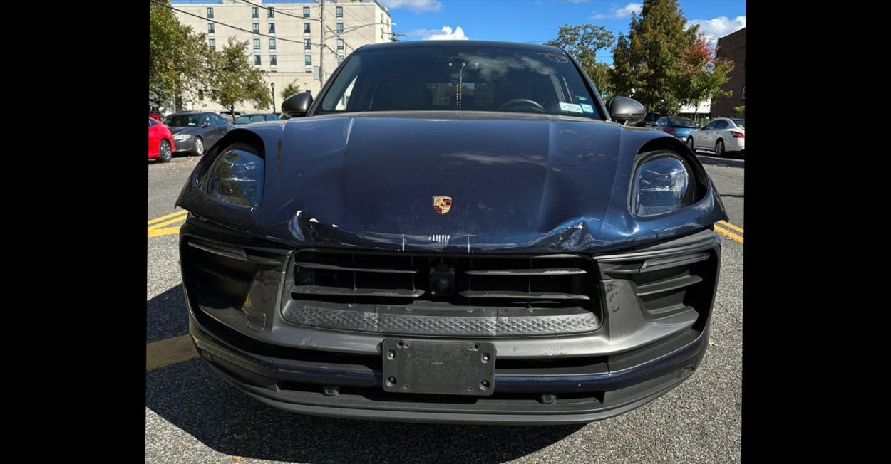 Dark blue Porsche Macan with front-end collision damage before repair